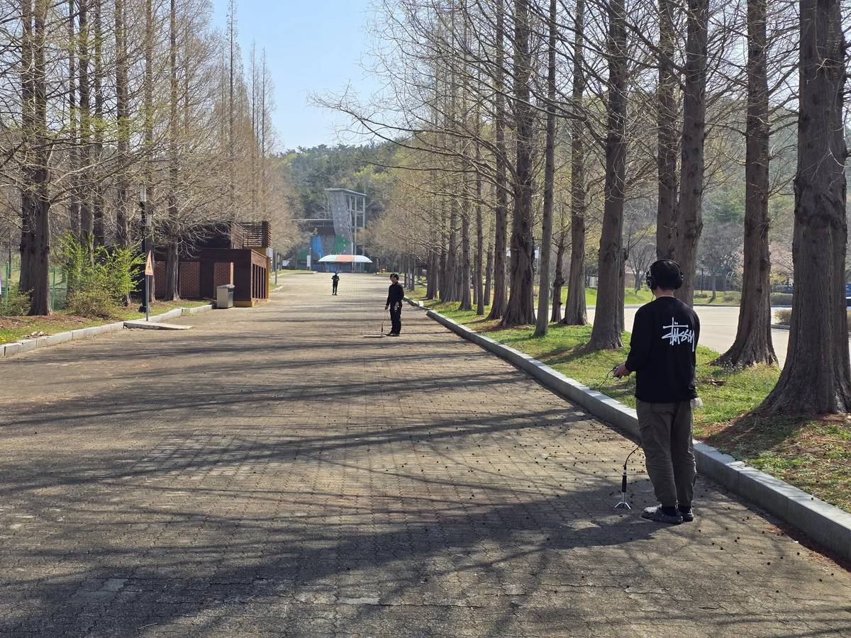 공원 산책로에서 청음 장비로 누수 지점을 확인하는 현장
